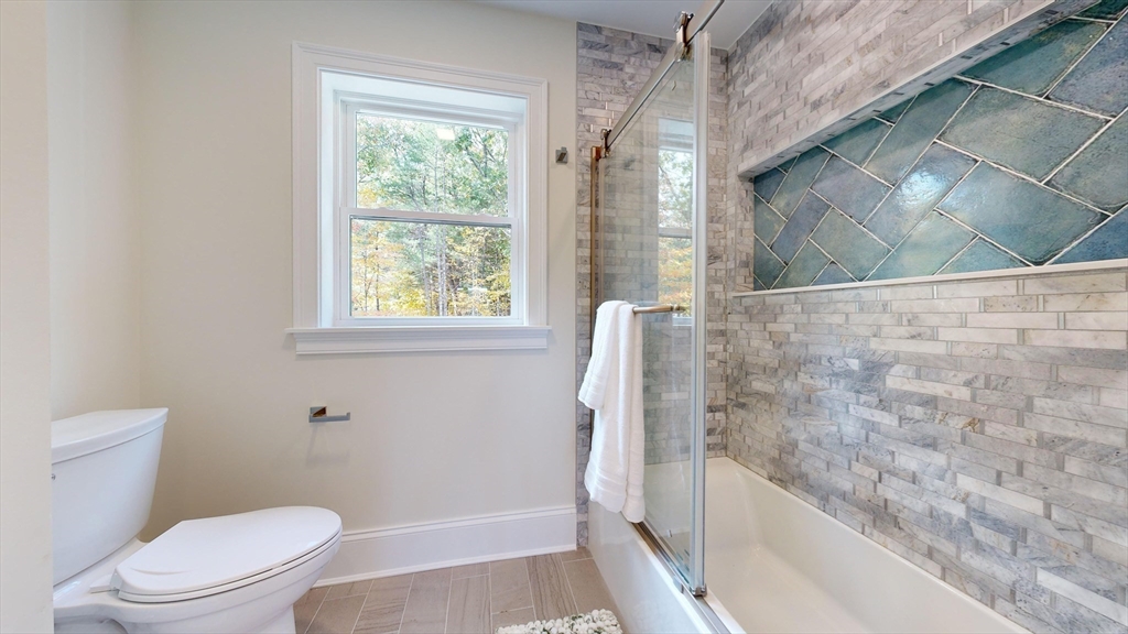 8 Charles Street North Reading, MA 01864 - Photo 32 of 42 a bathroom with a granite countertop bathtub a toilet and a shower
