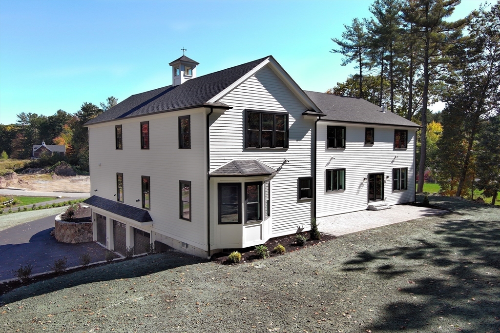8 Charles Street North Reading, MA 01864 - Photo 40 of 42 a view of a white house with large windows and a small yard