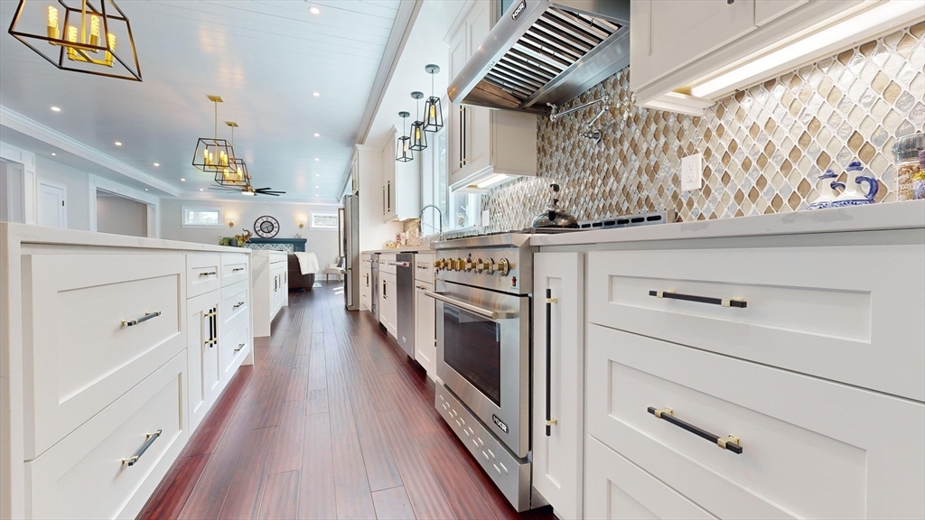 8 Charles Street North Reading, MA 01864 - Photo 6 of 42 a kitchen with stainless steel appliances white cabinets and wooden floors