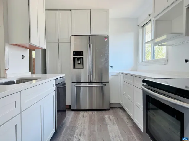 a kitchen with cabinets stainless steel appliances and sink