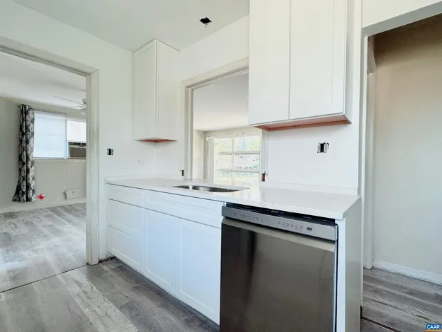 a kitchen with a sink cabinets and wooden floor