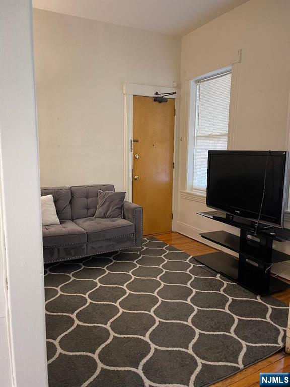 11 Preston Street, Unit 1E Ridgefield Park, NJ 07660 - Photo 8 of 12 a living room with a couch and a flat screen tv