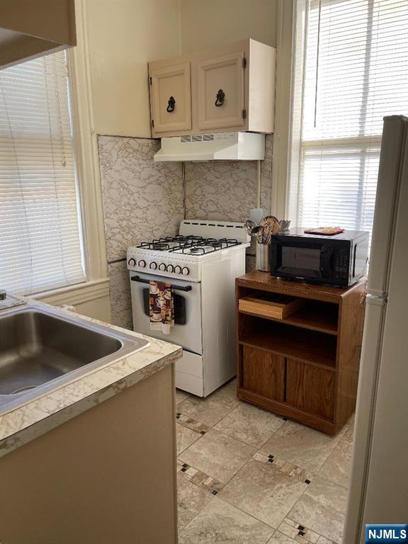 11 Preston Street, Unit 1E Ridgefield Park, NJ 07660 - Photo 10 of 12 a kitchen with a stove a sink and a refrigerator
