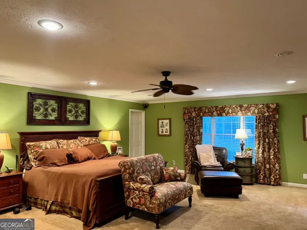 a spacious bedroom with a bed window and couch