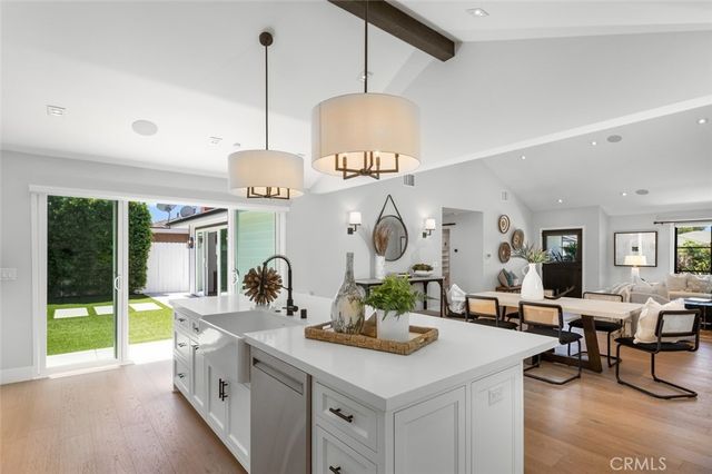 a very nice looking room with kitchen island furniture a large window and a sink