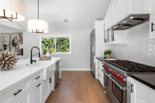 a kitchen with stainless steel appliances a sink stove and cabinets