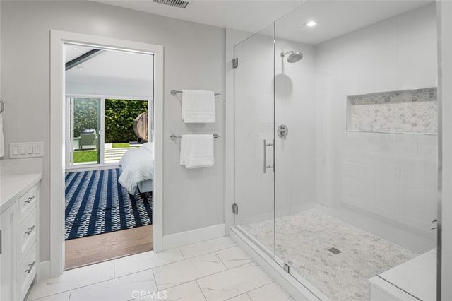 a bathroom with a glass shower door and a sink