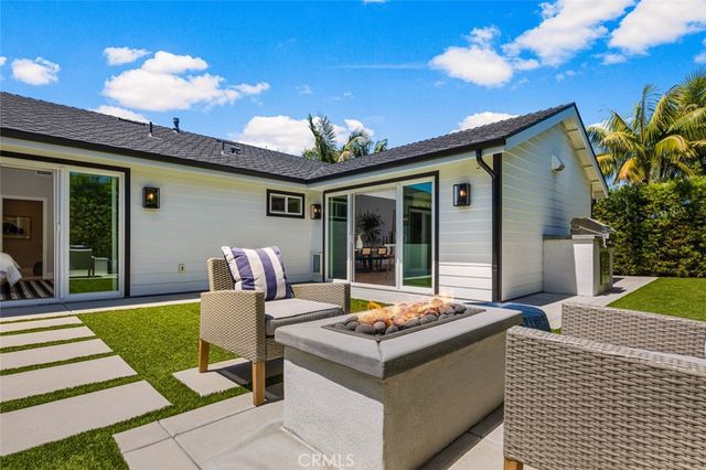a view of a patio with couches table and chairs with wooden floor and fence