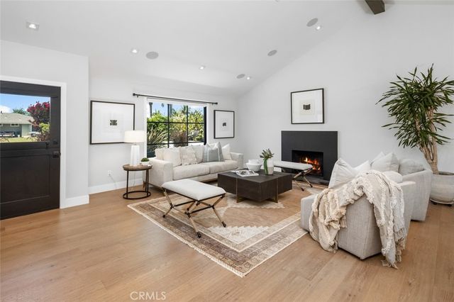 a living room with furniture fireplace and a large window