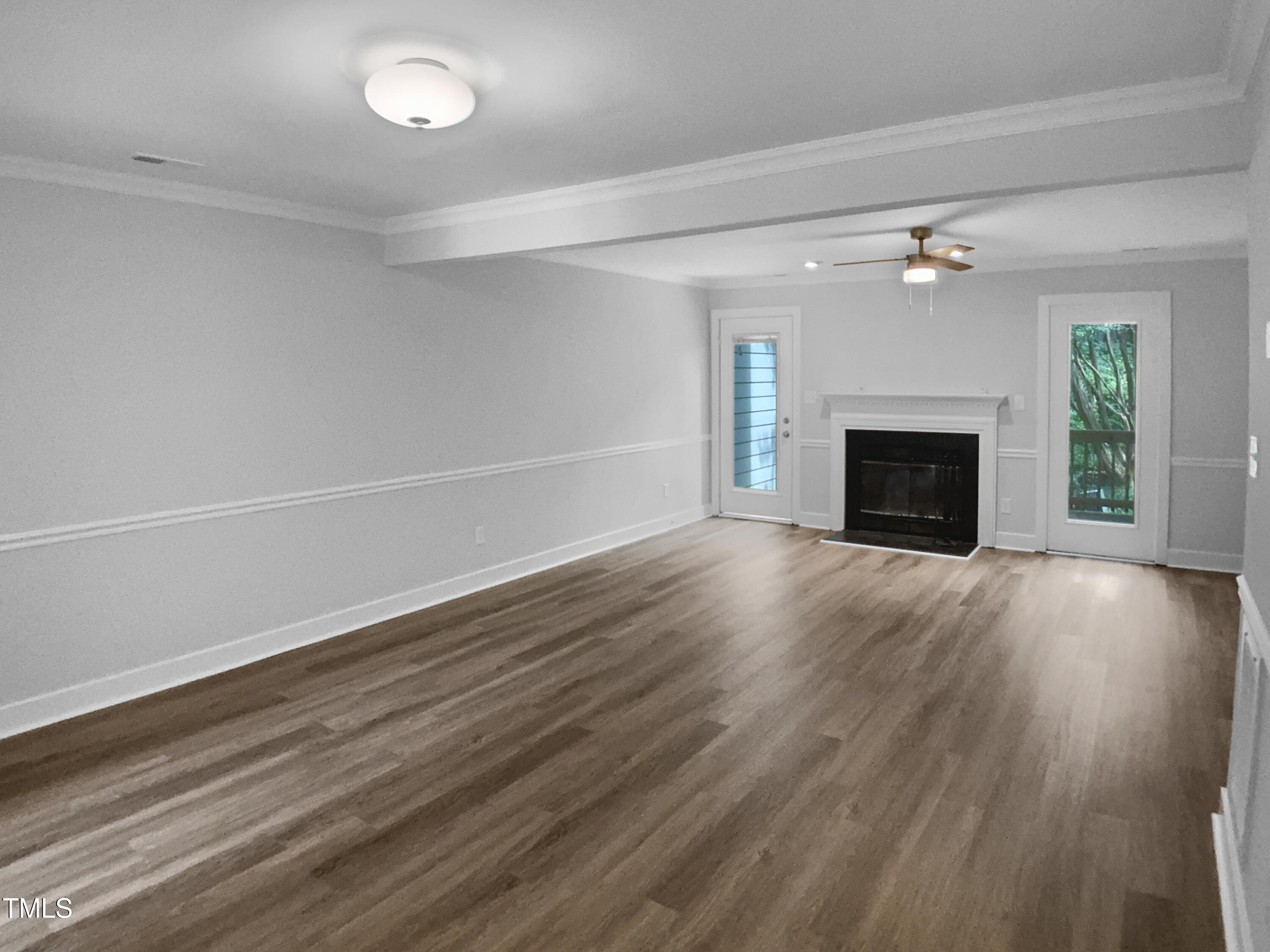 1432 Quarter Point Raleigh, NC 27615 - Photo 13 of 25 an empty room with wooden floor fireplace and windows