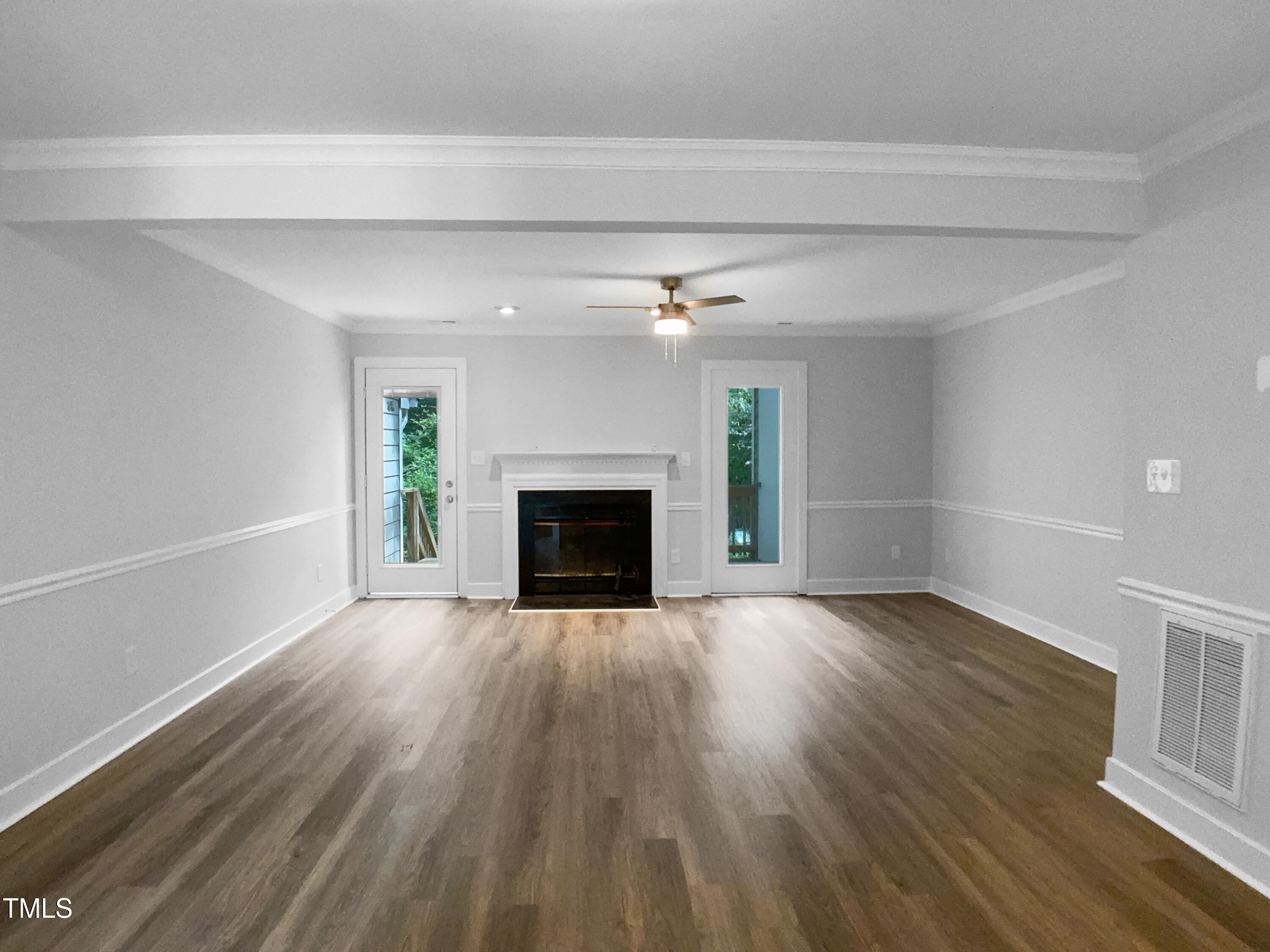 1432 Quarter Point Raleigh, NC 27615 - Photo 3 of 25 a view of an empty room with wooden floor fireplace and a window
