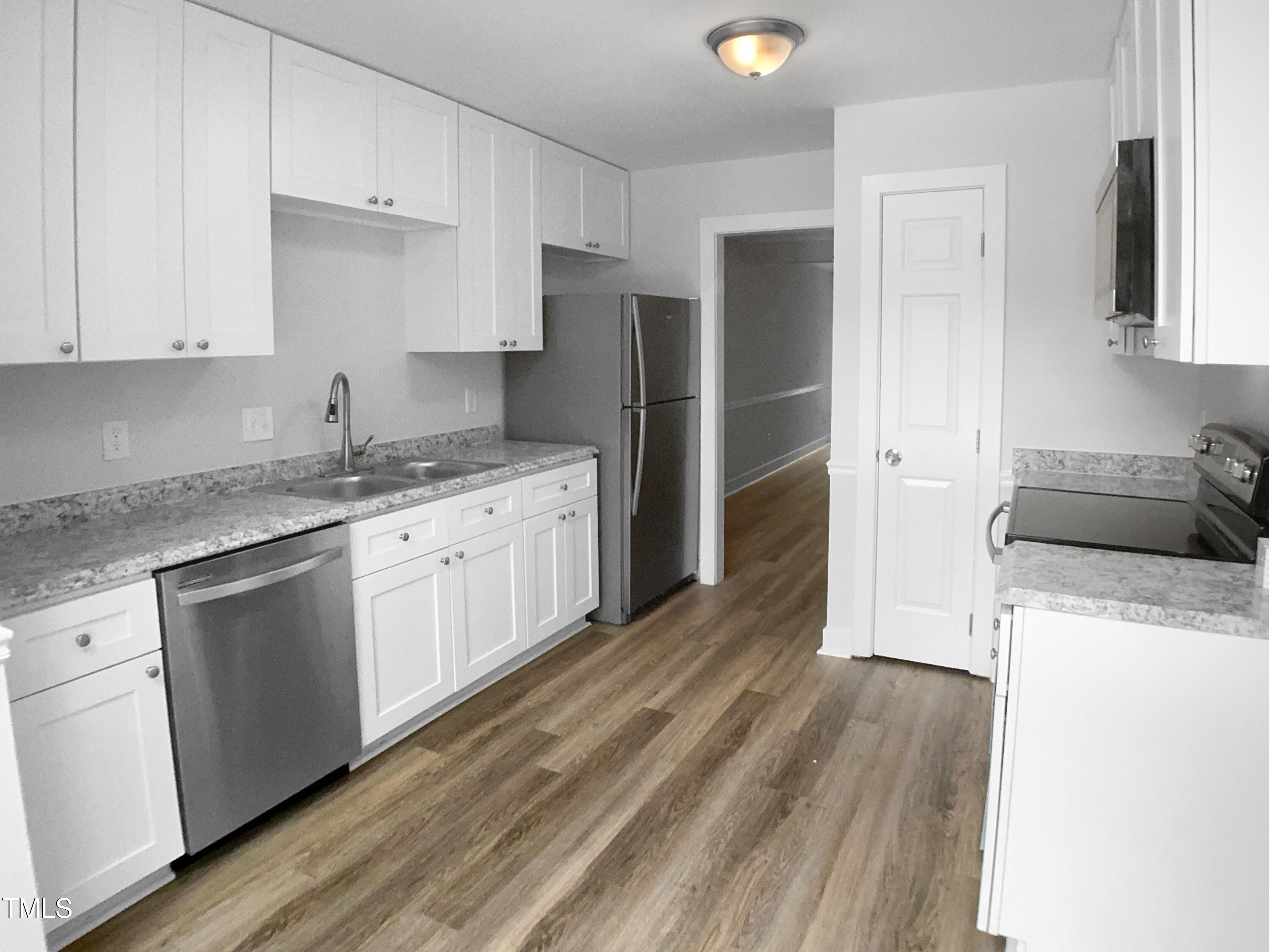1432 Quarter Point Raleigh, NC 27615 - Photo 6 of 25 a kitchen with granite countertop a refrigerator sink and white cabinets