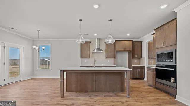 a open kitchen with stainless steel appliances granite countertop a stove refrigerator and a fireplace with wooden floor