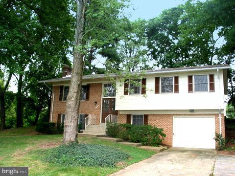 9700 Brookford Road Potomac, MD 20854 - Photo 2 of 29 a front view of a house with a garden and trees