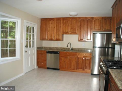 9700 Brookford Road Potomac, MD 20854 - Photo 12 of 29 a kitchen with granite countertop stainless steel appliances a refrigerator stove top oven and sink