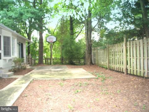 9700 Brookford Road Potomac, MD 20854 - Photo 27 of 29 a view of a backyard with large trees and wooden fence