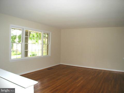 9700 Brookford Road Potomac, MD 20854 - Photo 6 of 29 an empty room with wooden floor and windows