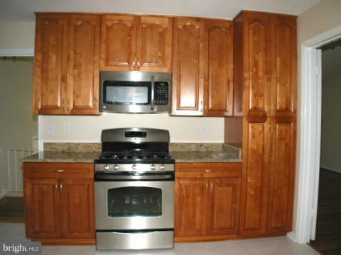 9700 Brookford Road Potomac, MD 20854 - Photo 10 of 29 a kitchen with granite countertop wood cabinets and stainless steel appliances