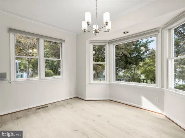 a view of a livingroom with a fireplace wooden floor and a ceiling fan