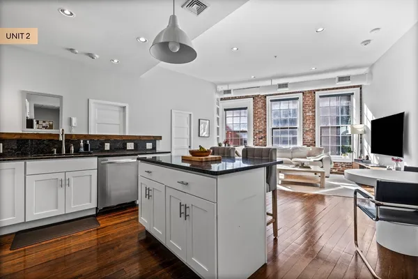 a kitchen with white cabinets and sink