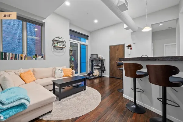 a living room with furniture and a wooden floor