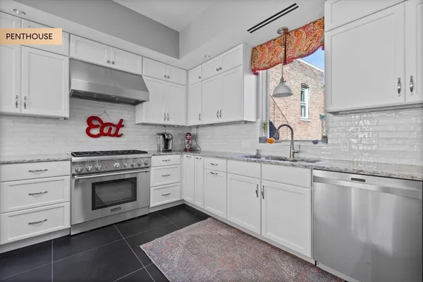a kitchen with stainless steel appliances granite countertop a sink cabinets and a wooden floor