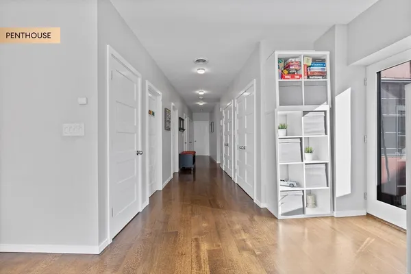 a view of a hallway with wooden floor and entryway