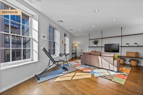 a living room with furniture gym equipment and a flat screen tv