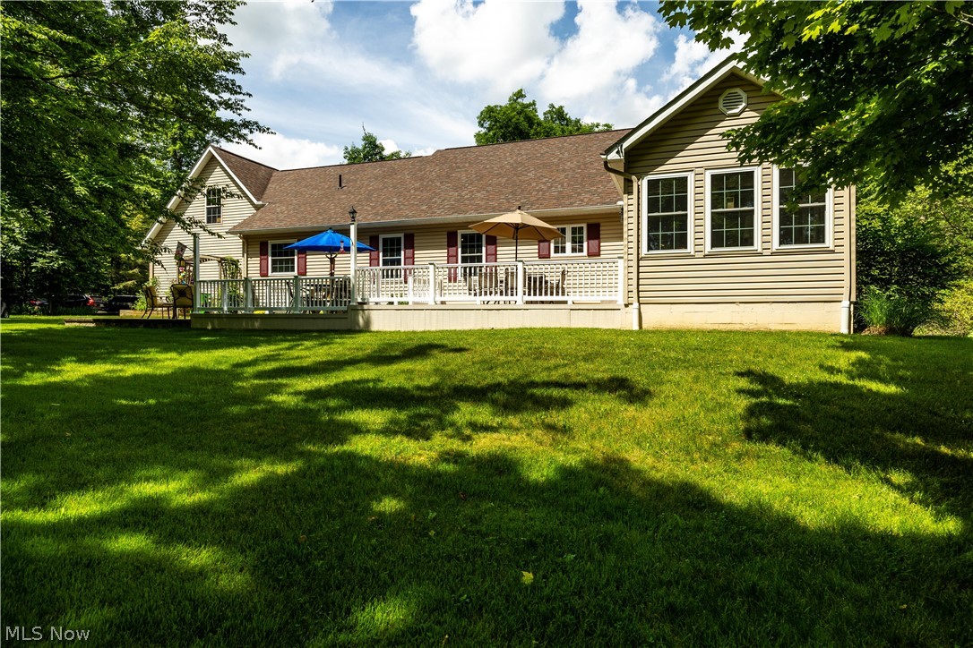 8737 River Corners Road Homerville, OH 44235 - Photo 35 of 46 Back of property with a wooden deck and a lawn