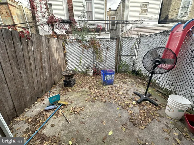 a backyard of a house with barbeque oven table and chairs