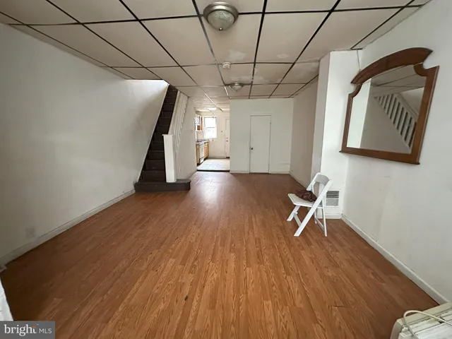 a view of a livingroom with wooden floor and a hallway