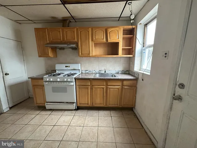 a kitchen with a stove sink and cabinets