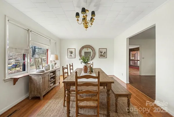 a view of a dining room with furniture a chandelier and wooden floor