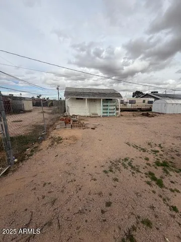 a view of a dry yard with wooden fence