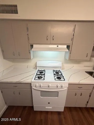 a white stove top oven sitting inside of a kitchen