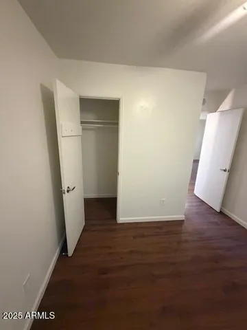 an empty room with wooden floor and cabinet