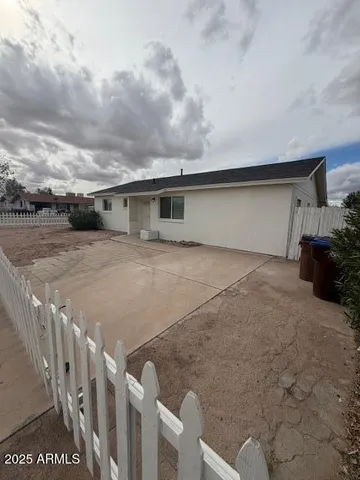 a view of an house with backyard and bushes