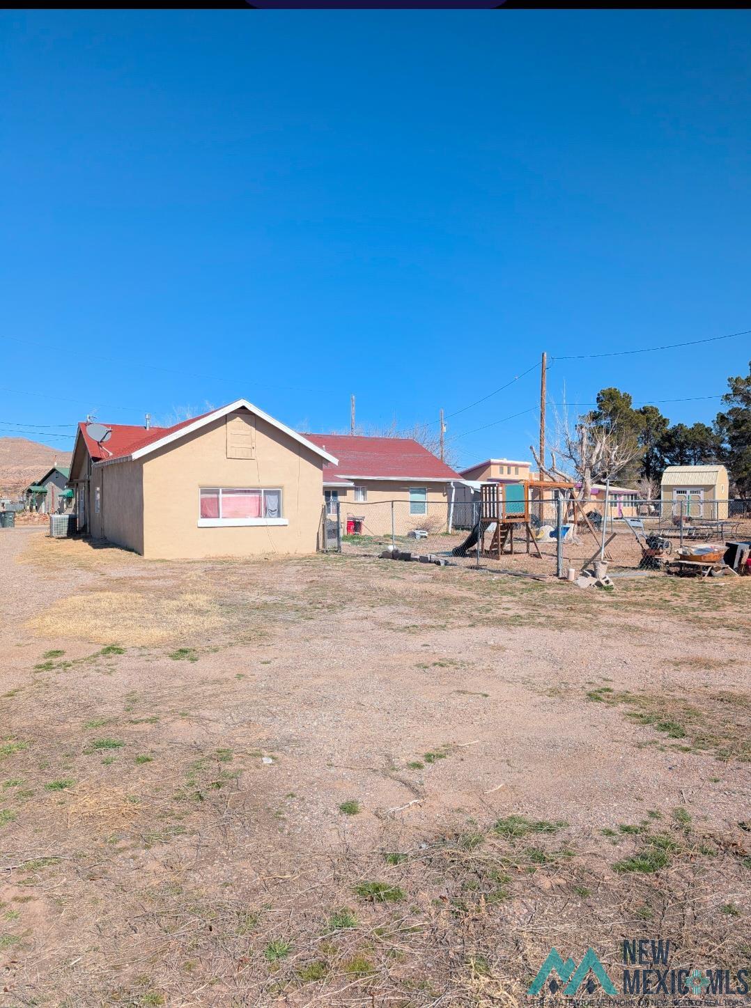 608 Del Rio Street Truth Or Consequences, NM 87901 - Photo 2 of 16 Rear view of house with a playground