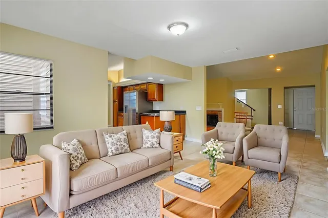 a living room with furniture kitchen view and a window