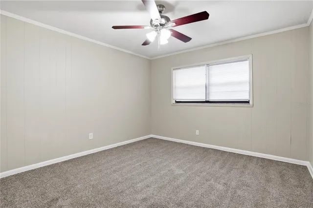 an empty room with a window and a fan
