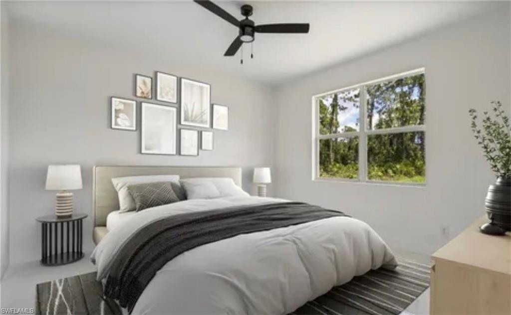 2512 9th Street Southwest Lehigh Acres, FL 33976 - Photo 7 of 10 a bedroom with a bed and wooden floor