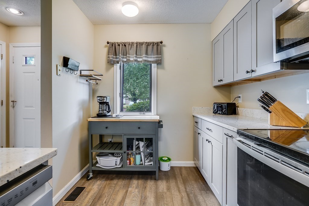 31 Hunters Run Place, Unit 31 Haverhill, MA 01832 - Photo 3 of 32 a kitchen with cabinets and wooden floor