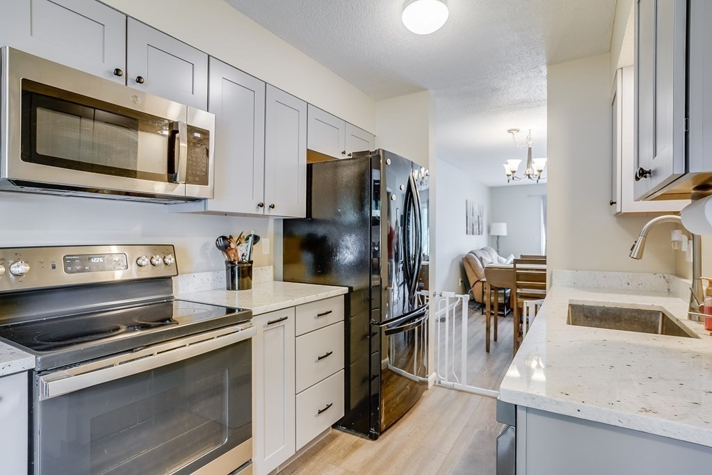 31 Hunters Run Place, Unit 31 Haverhill, MA 01832 - Photo 4 of 32 a kitchen with a sink stove and refrigerator