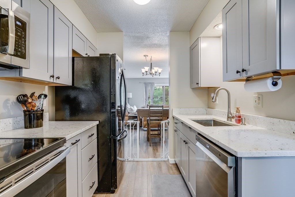 31 Hunters Run Place, Unit 31 Haverhill, MA 01832 - Photo 5 of 32 a kitchen with a sink a stove and chairs