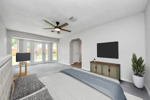 a bedroom with a bed window and a flat screen tv