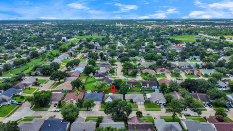 an aerial view of residential houses with outdoor space and trees