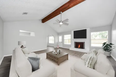 a living room with furniture a fireplace and a flat screen tv