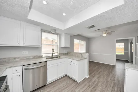 a kitchen with granite countertop white cabinets and white appliances