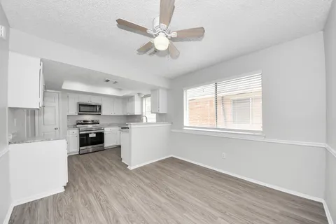 a view of kitchen with sink microwave refrigerator and cabinets
