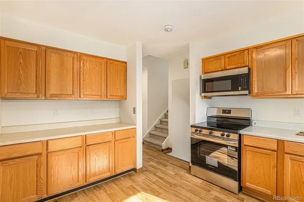 a kitchen with stainless steel appliances granite countertop a stove a sink and a microwave